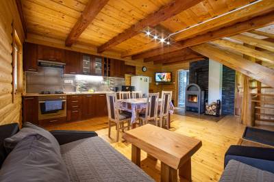 Obývačka s gaučom a kachľami prepojená s kuchyňou, Chata pod Rožkom, Uličské Krivé