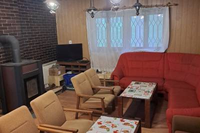 Obývačka s gaučami, kreslami, TV a kachľami, Chata Martinské Hole, Martin